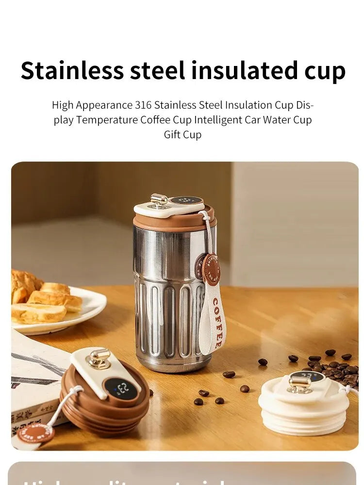 Stainless steel insulated cup with digital temperature display on a wooden table with coffee beans and pastries.