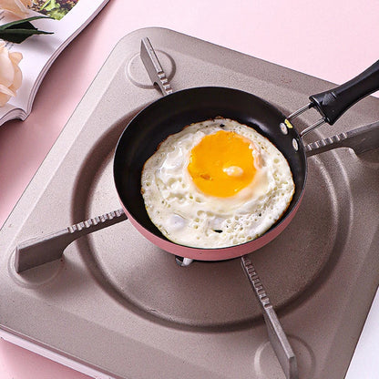 Fried egg in a frying pan on a stove with a magazine in the background