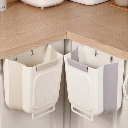 White and gray hanging trash bins attached to a kitchen cabinet.