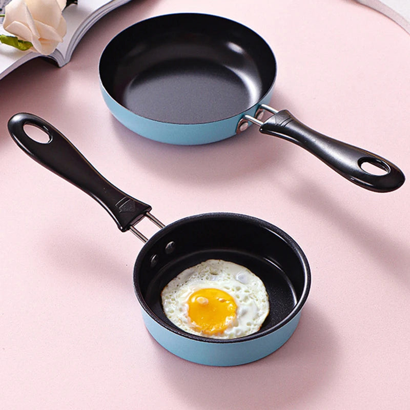 Small frying pan with a fried egg on a pink surface