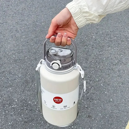 Hand holding a white thermos with a gray lid on a gray pavement background