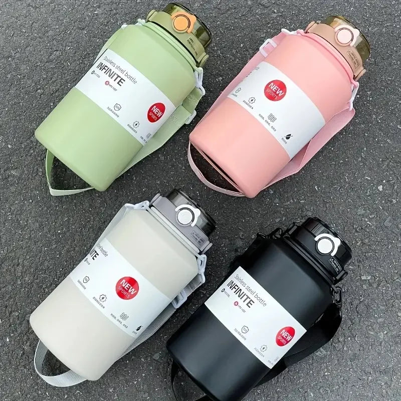 Four water bottles in different colors on a gray surface