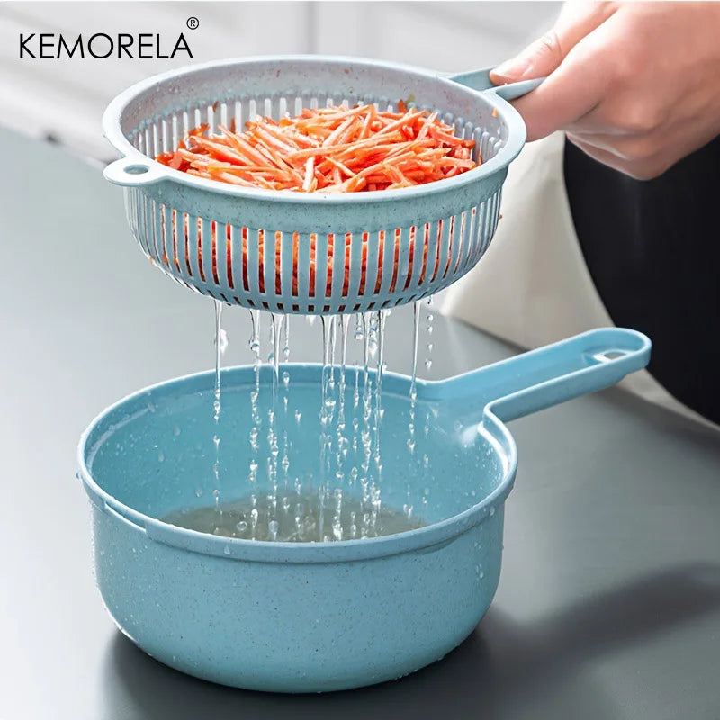 Blue colander with carrots being rinsed, brand 'KEMORELA' visible
