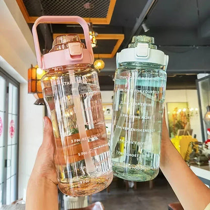 Two water bottles held in hands with a blurred indoor background