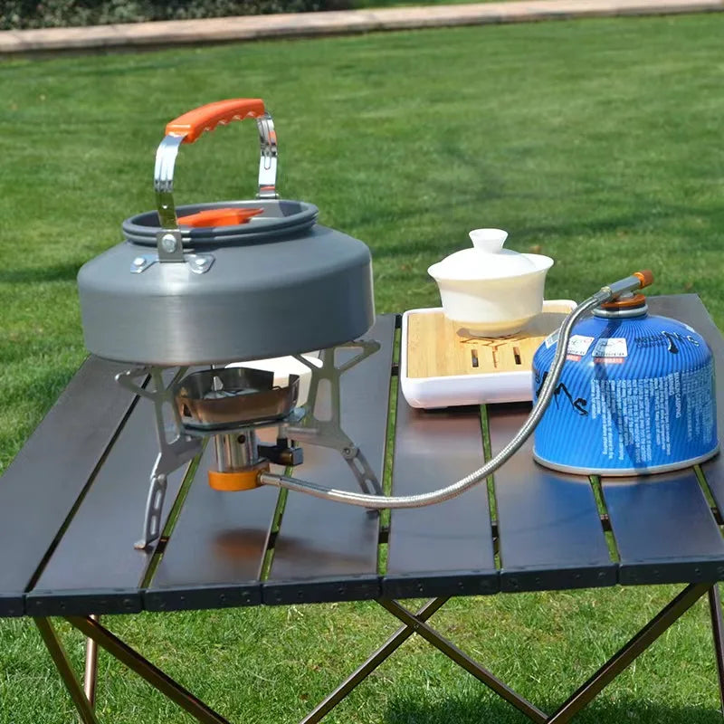 Camping stove with accessories on a table outdoors